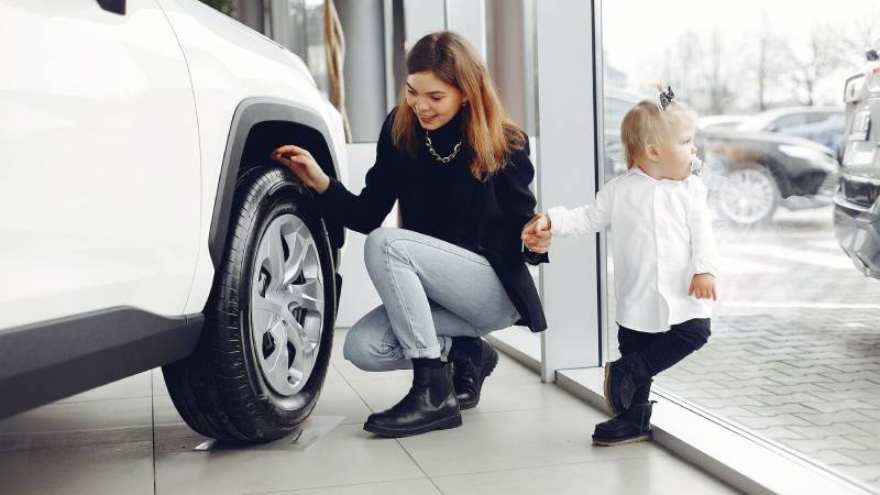 researching white car with woman and baby